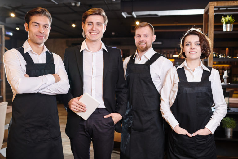 restaurant servers and manager posing in uniform