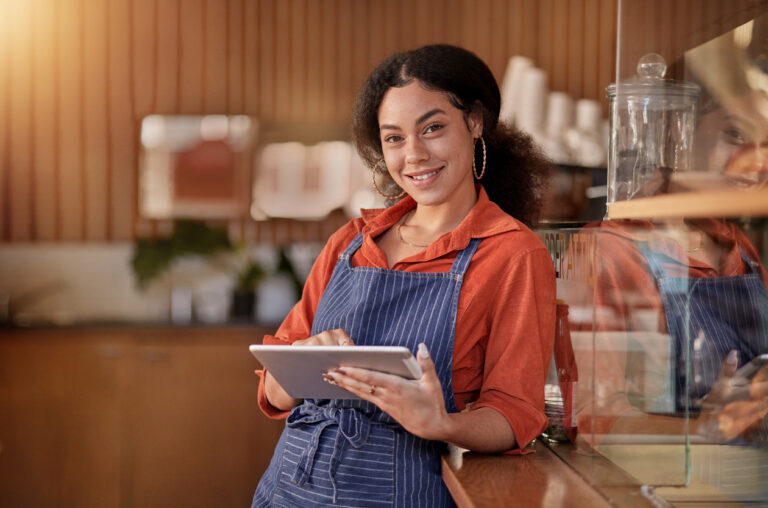 Portrait, cafe waiter and black woman with tablet to manage orders, inventory and stock. Coffee shop barista, technology and happy female waitress with touchscreen for managing sales in restaurant.