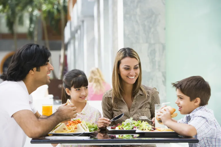 Family enjoying meal sitting at cafe table